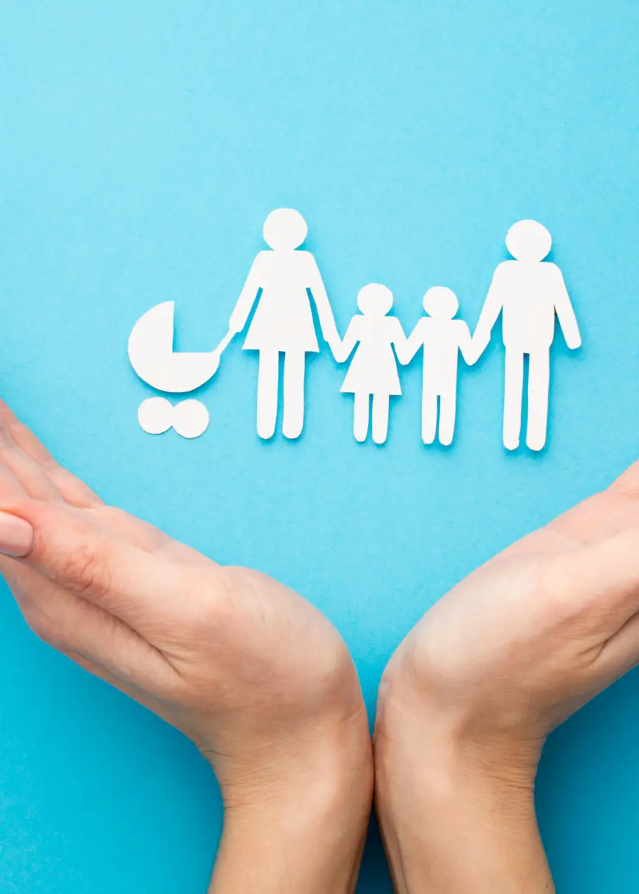 Mains protégeant une famille en papier découpé, symbole de l'assurance emprunteur