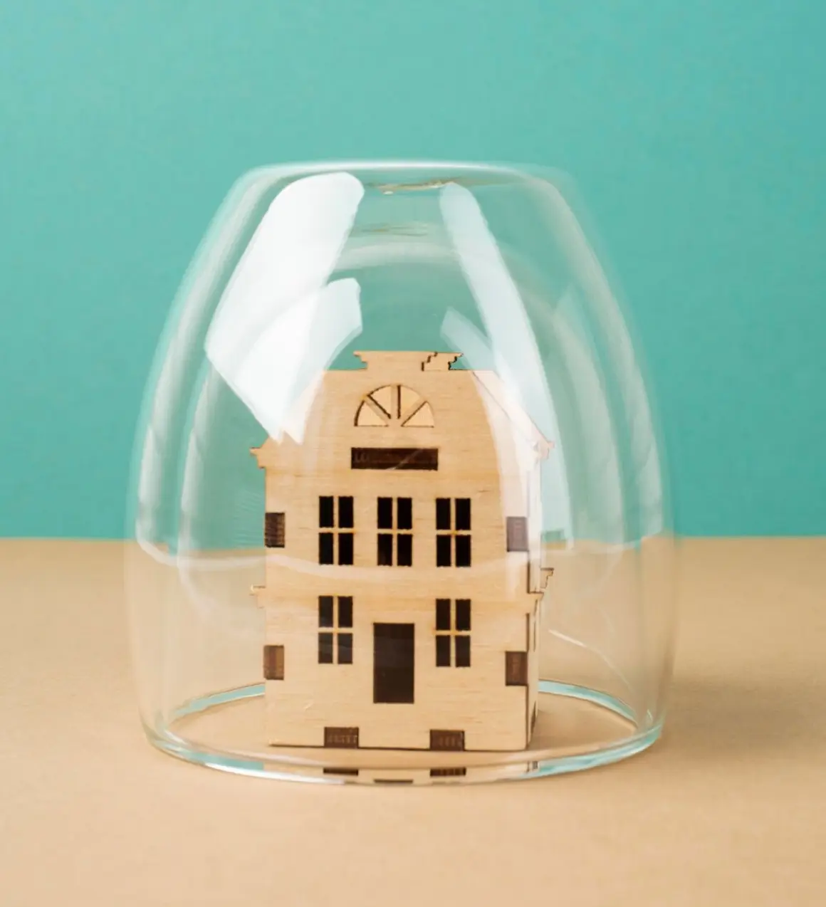 Maison miniature protégée sous une cloche de verre